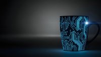 Blue circuit board pattern coffee mug on dark background with dramatic lighting for technology and electronics themed designs.