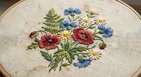 Embroidered wildflower bouquet with colorful blooms in wooden hoop on natural linen fabric for crafting and home decor projects.
