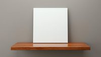 Blank white canvas on wooden shelf against neutral wall, minimalist art display mockup for gallery exhibition or home decor presentation.