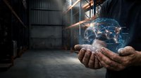 Hands holding glowing digital brain with neural network connections in industrial warehouse setting for technology and artificial intelligence concepts.