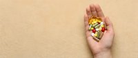 Young adult hand holding assorted pharmaceutical pills and capsules on neutral beige background, representing medication, healthcare, wellness, and pharmaceutical industry concepts.