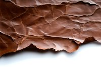Crumpled brown paper with dramatic shadows and textural detail creates abstract pattern on white background, isolated for creative design projects and layouts.