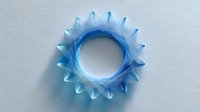 Ethereal blue circular geometric pattern with spiky edges and gradient transparency on light background, creating depth and dimension. Suitable for modern design.