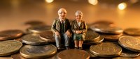 Elderly couple sitting on large coins representing retirement savings and financial security planning for senior years with warm golden lighting.