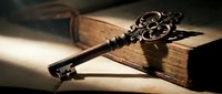 Antique ornate skeleton key resting on an old vintage book in dramatic moody lighting, evoking mystery, history, and secret knowledge.