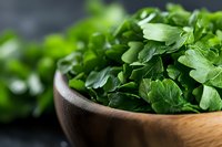 Fresh organic watercress leaves in wooden bowl on dark background, macro view of healthy green salad herbs for cooking and garnishing dishes.