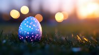 Glowing Easter egg decorated with stars pattern rests in grass at sunset, with magical bokeh lights creating dreamy atmosphere in background.