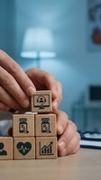 Hands arranging wooden blocks with healthcare and medical icons in modern clinic setting for telemedicine and digital health concepts.