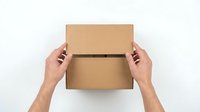 Hands opening cardboard box on white background, top view of unboxing delivery package for shipping and logistics design.