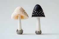 Contrasting decorative mushrooms with textured caps - one cream-colored and one dark blue with white dots, both featuring white stems and speckled bases.