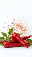 Fresh red chili peppers with green leaves and exploding spice powder on white background, isolated for food and culinary design use.