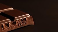Milk chocolate bars with airy texture and smooth surface on dark background for confectionery and dessert advertising projects.