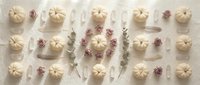 Elegant flat lay arrangement of white pumpkins and dried purple flowers on neutral background for autumn seasonal decor and harvest celebration designs.