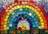 Vibrant rainbow mosaic arch made with colorful glass tiles in traditional style. Red sun rises from bottom creating dynamic semicircular pattern against white background.