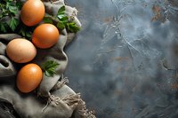 Fresh brown chicken eggs on rustic linen cloth with green parsley leaves against dark textured background with copy space for food photography.