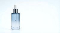 Blue glass serum bottle with dropper on white background isolated for skincare cosmetic product design and beauty branding applications.