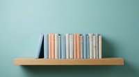 Colorful books arranged on wooden shelf against mint green wall creating minimalist home library display for interior design and education concepts.