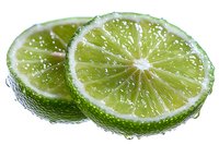 Fresh lime slices with water drops on white background, macro shot showing juicy citrus fruit texture and natural green pulp segments for food design.