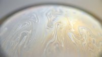 Swirled marble texture with cream and gray tones creating fluid, organic patterns. Suitable for backgrounds, wallpapers, and design projects.