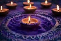 Glowing tea light candles arranged in spiral pattern on purple mandala textile create mystical atmosphere for meditation, spirituality and relaxation practices.