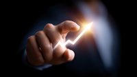 Businessman finger touching glowing arrow pointing upward on dark background, representing business growth, success and positive financial trend analysis.