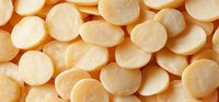 Raw sliced potatoes arranged in overlapping circular pattern, showing fresh vegetable preparation for cooking or food processing.