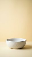 Empty ceramic bowl with speckled texture on neutral beige background for kitchen and dining product photography.