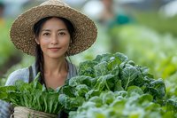 Asian woman farmer in straw hat holding fresh harvested organic vegetables and greens in woven basket, sustainable agriculture and local farming concept.