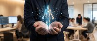 Businessman in dark suit holding glowing digital human figure with particle effects in modern office environment with blurred colleagues working at desks in background.