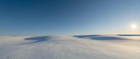 Vast snowy landscape with distant mountains under clear blue sky at sunrise or sunset. Minimalist winter scenery for travel, nature, and seasonal design projects.