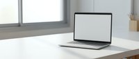 Modern laptop computer with blank white screen on clean white desk in bright office workspace for business presentations and mockup designs.
