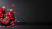 Glittering red hearts with sparkly texture scattered on dark background, romantic holiday decoration with small heart confetti creating festive atmosphere.