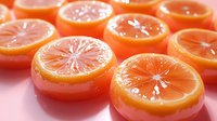 Fresh juicy orange slices arranged in rows on pink background with soft focus and selective lighting creating appetizing citrus fruit composition.