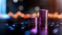 Stacks of metallic coins illuminated by purple and orange lights against dark background with bokeh effect, symbolizing financial growth and investment.