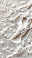 Creamy coffee foam texture with bubbles and swirls, abstract background for food photography and beverage marketing.