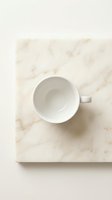 Empty white ceramic mug on marble surface, overhead view. Minimalist flat lay composition for beverage, coffee, tea, and kitchen product mockups.