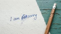 Handwritten apology note reading I am so sorry on textured paper with a pencil beside it, conveying regret, forgiveness, and sincere emotion.