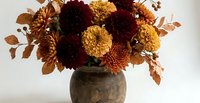 Autumn chrysanthemum bouquet in rustic ceramic vase with burgundy and golden blooms, dried foliage for seasonal home decor and fall arrangements.