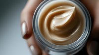 Luxurious cream moisturizer in glass jar with leaf-shaped swirl pattern, showcasing premium skincare product texture against blurred background. For beauty and cosmetic marketing.