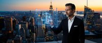 Professional businessman using holographic technology interface overlooking city skyline at sunset for futuristic business concepts and digital innovation.