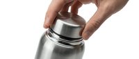 Male hand opening stainless steel thermos bottle cap on white background for beverage storage and temperature control applications.