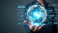 Businessman holding glowing digital globe with shield icon representing cybersecurity and data protection technology for global business networks.
