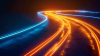 Glowing orange and blue light trails curve along dark highway at night creating dynamic motion effect, abstract background for technology and future concepts.