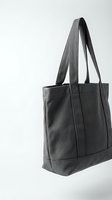 Black canvas tote bag with long handles isolated on white background for shopping, work, and everyday use accessories.