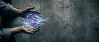 Male hands holding glowing purple energy sphere with magical light effects on dark concrete surface for fantasy and supernatural concepts.