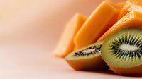 Sliced kiwi fruit with orange carrots on neutral background, suitable for food, nutrition, healthy eating, and culinary design projects.
