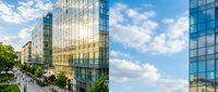 Modern glass and steel office buildings with reflective facades line a sunny urban street with pedestrians and green trees, suitable for corporate, real estate, and business website design.
