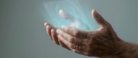 Elderly hands holding futuristic holographic interface with glowing digital elements for technology and innovation concepts.