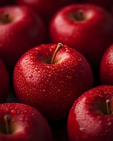 Fresh red apples with water droplets on dark background, macro shot showing detailed texture and natural moisture on shiny fruit surface. Perfect for food and harvest themes.