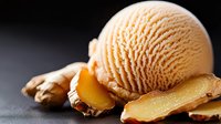 Creamy orange ice cream scoop with caramelized almond slices on dark background, selective focus. Gourmet frozen dessert with nutty garnish.